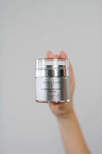 Hand holding Flora Lane Barrier Restore Cream — skin barrier repair in perimenopause